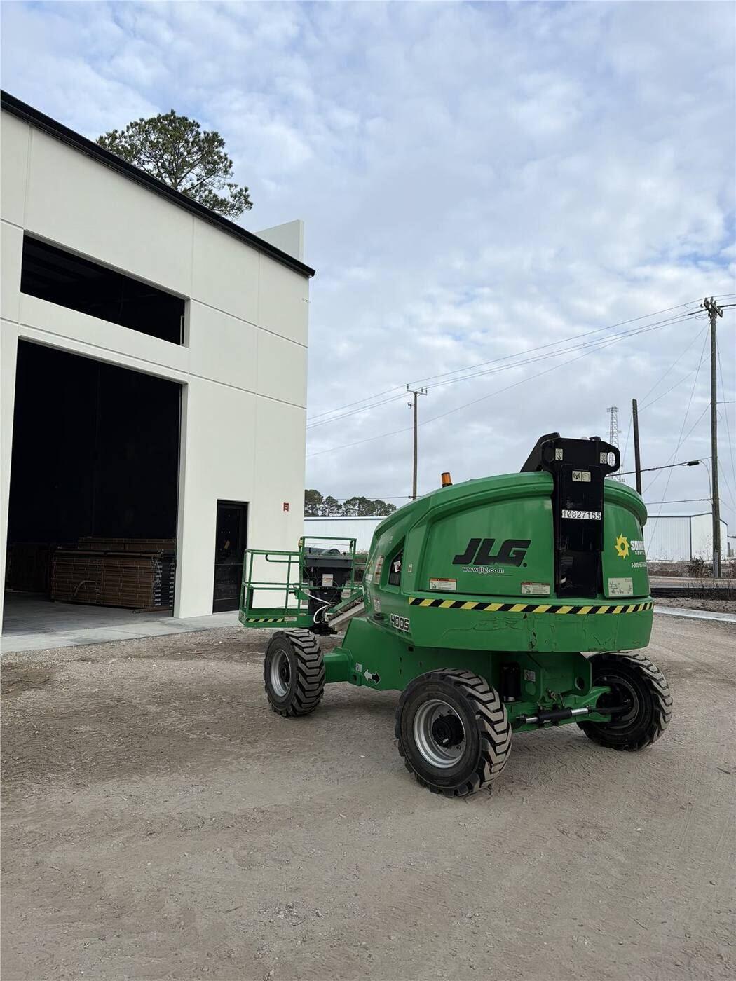 Boom lift positioned for commercial gutter installation on a North Florida facility