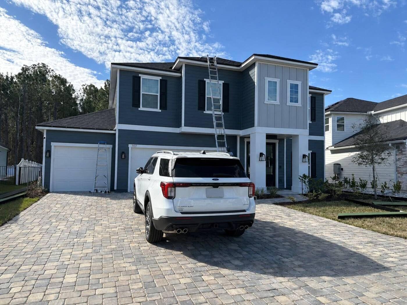 Seamless gutter installation on the front of a two-story home